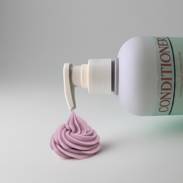 Bottle of conditioner with a pump and a sample of blue grey conditioner on a grey background