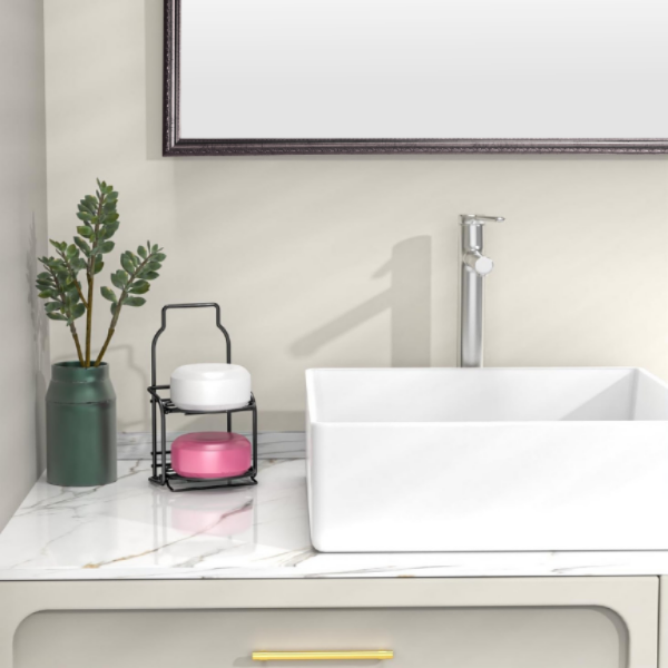 Modern bathroom with a white sink, plant, and decorative items on a marble countertop.